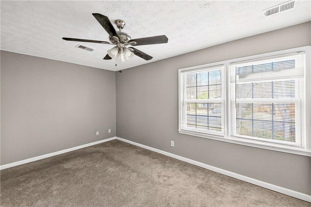 1075 Forest Heights Road Stone Mountain, GA 30083 - Photo 21 of 42 an empty room with windows and fan