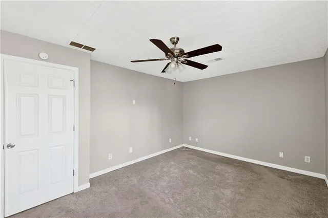 an empty room with a ceiling fan and a window