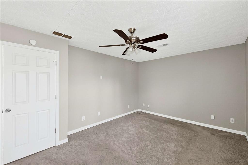 1075 Forest Heights Road Stone Mountain, GA 30083 - Photo 23 of 42 an empty room with a ceiling fan and a window
