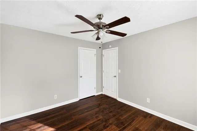 a view of room with wooden floor and ceiling fan