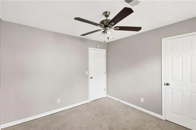 an empty room with a window and a fan