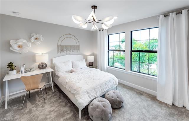 3974 East Hampton Circle Fort Myers, FL 33905 - Photo 13 of 36 a bedroom with a bed and a chandelier