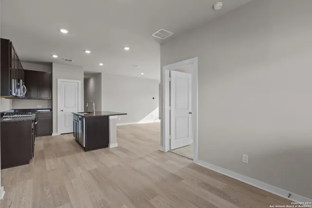 a view of kitchen with stainless steel appliances wooden floor and large window