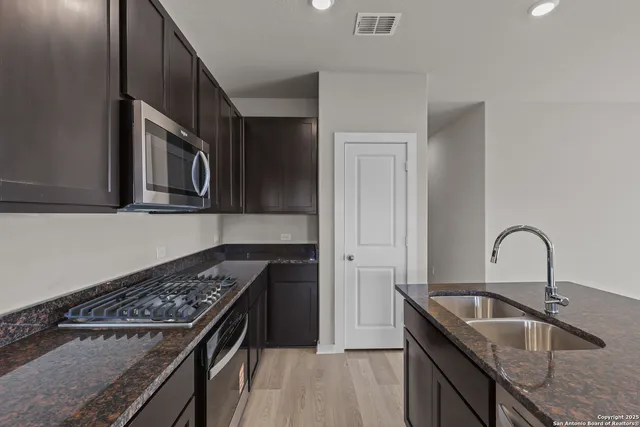 a kitchen with granite countertop a stove and a sink