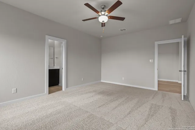 a view of an empty room and a ceiling fan