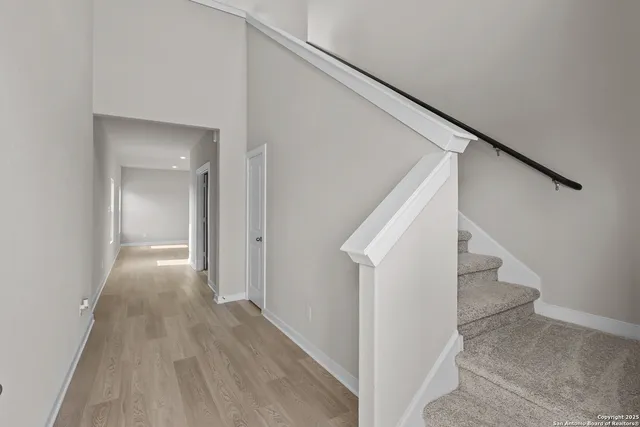 a view of a hallway with wooden floor and entryway