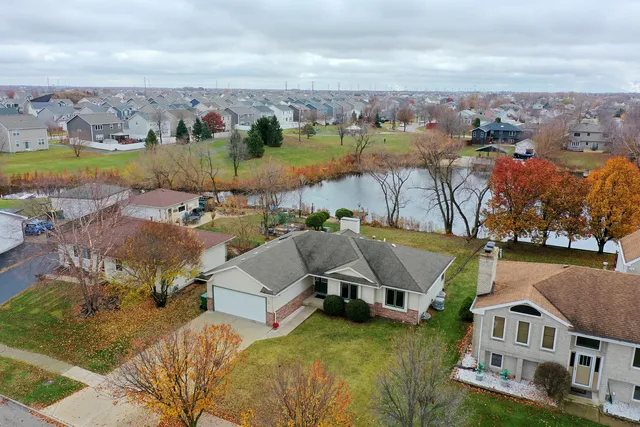 an aerial view of ocean and residential houses with outdoor space