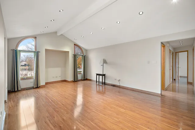 a view of an empty room with wooden floor