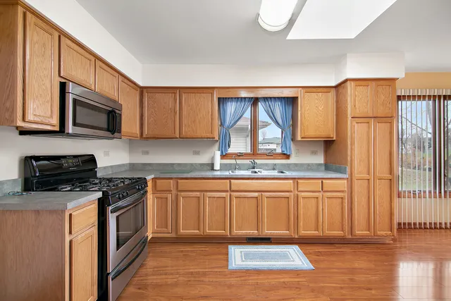 a kitchen with stainless steel appliances a refrigerator sink and microwave