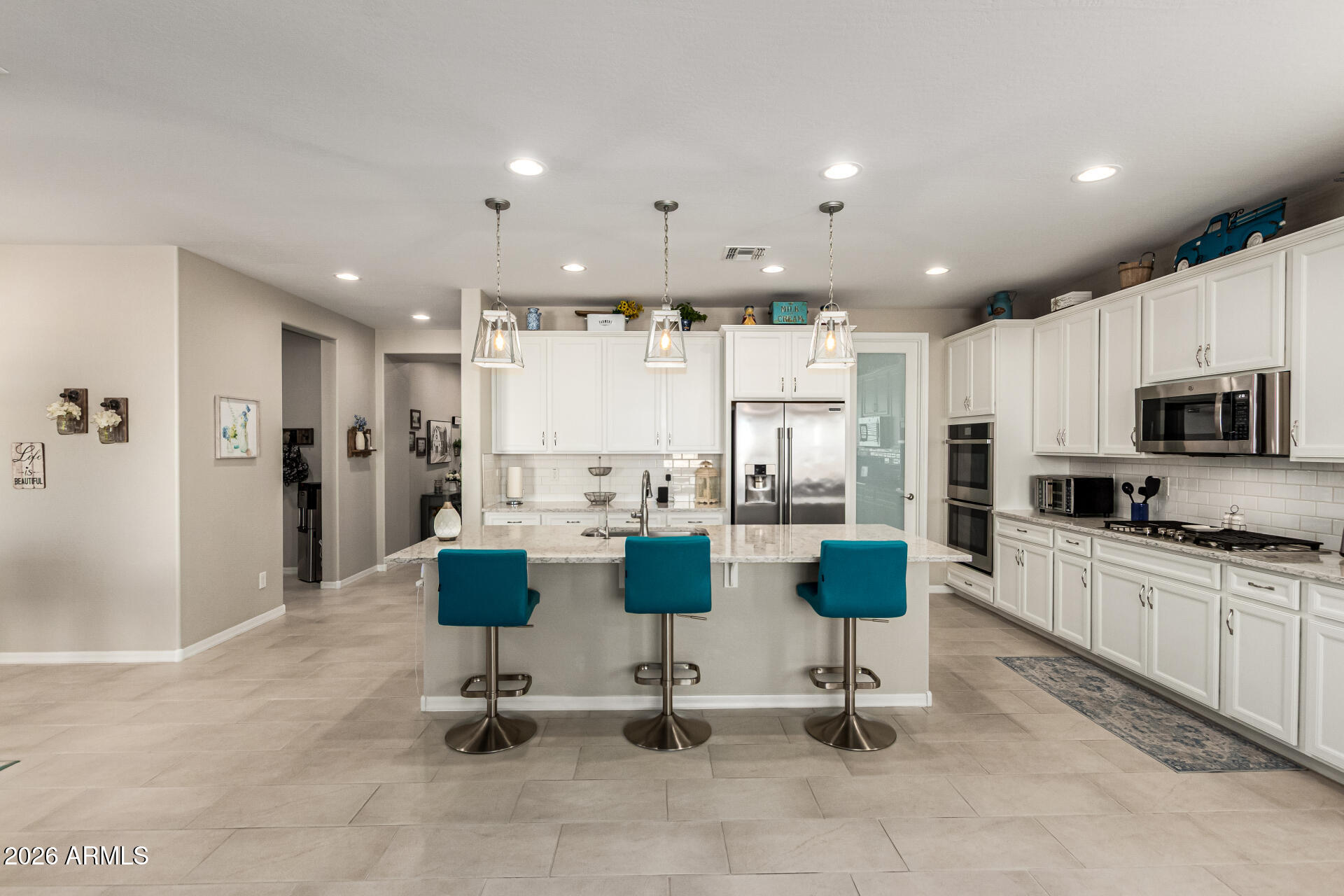 22494 East Russet Road Queen Creek, AZ 85142 - Photo 14 of 43 a view of kitchen with kitchen island stainless steel appliances refrigerator stove microwave and cabinets