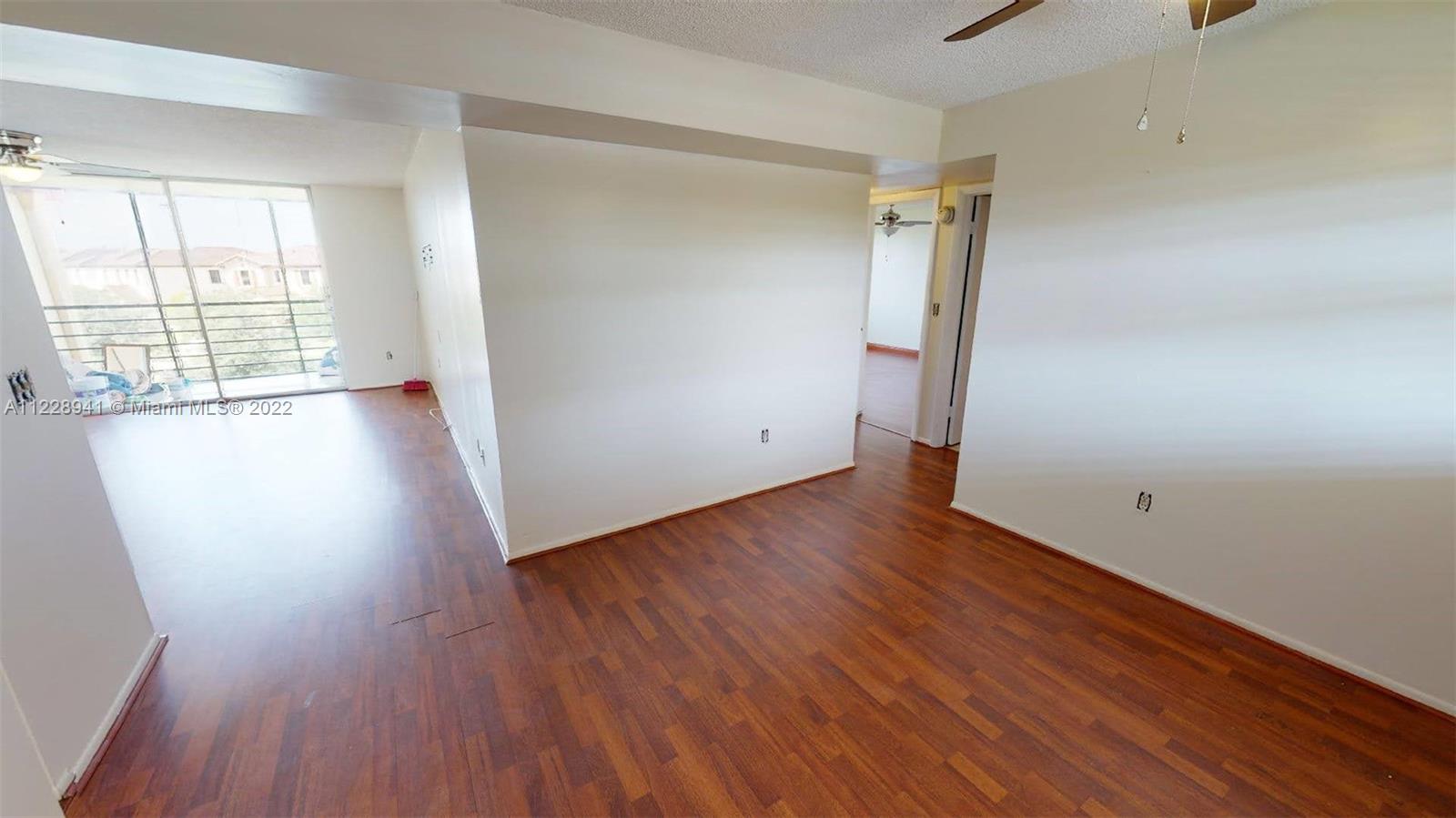 3490 Foxcroft Road, Unit B305 Miramar, FL 33025 - Photo 3 of 30 an empty room with wooden floor and windows