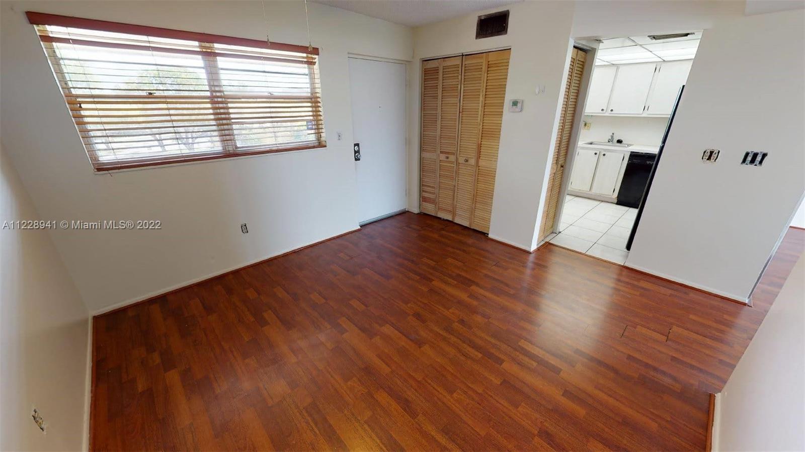 3490 Foxcroft Road, Unit B305 Miramar, FL 33025 - Photo 9 of 30 a view of an empty room with wooden floor and a window