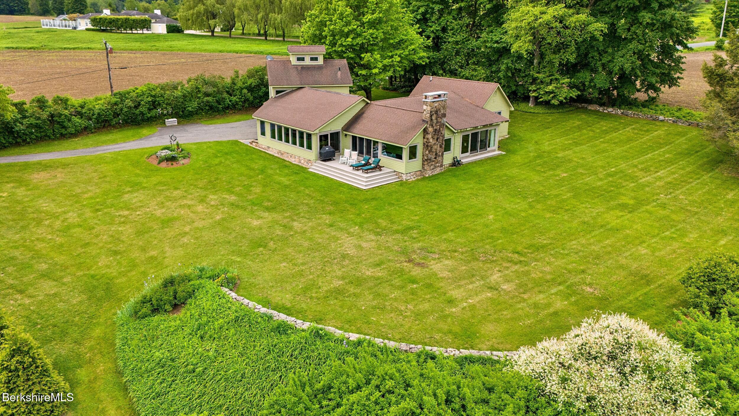 an aerial view of a house with swimming pool garden and patio