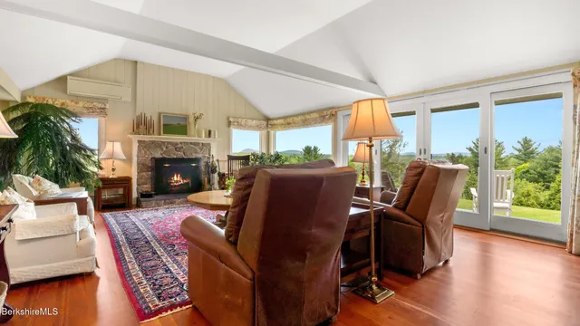 a living room with furniture large window and a fireplace