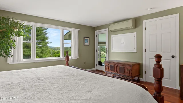 a bedroom with a bed and large windows