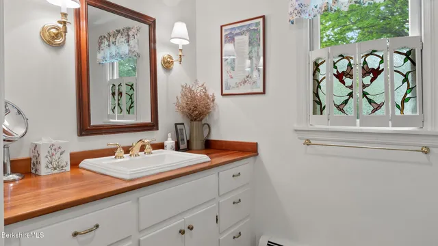 a bathroom with a sink a mirror and a window