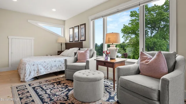 a bedroom with furniture and a large window