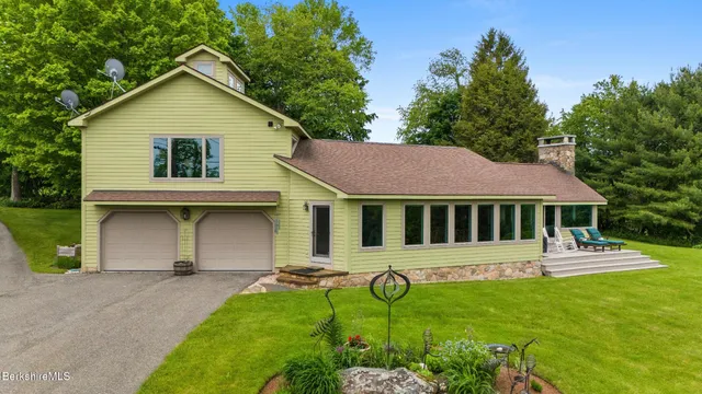 a view of a house with backyard and a garden