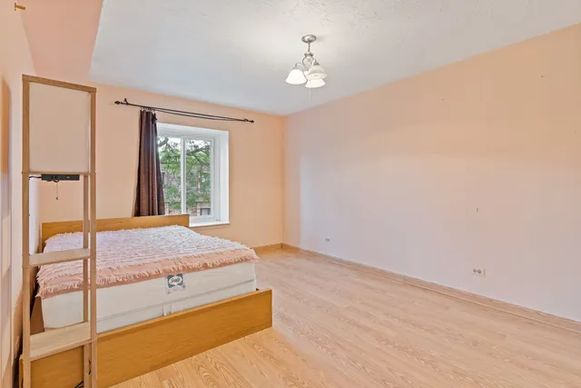 a spacious bedroom with a bed and a window