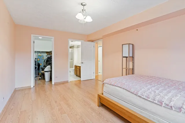 a spacious bedroom with a bed and a chandelier
