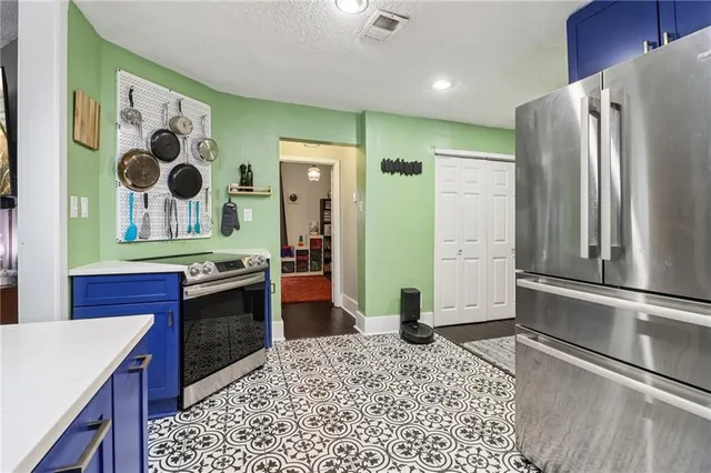 a kitchen with stainless steel appliances granite countertop a refrigerator a stove and a sink