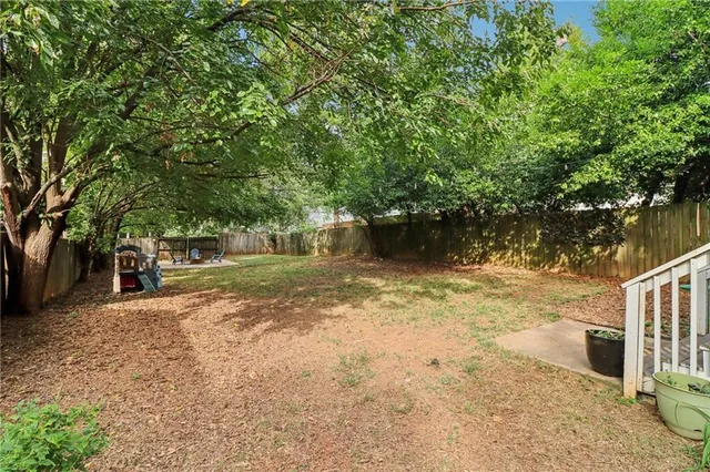 a view of a yard with plants and trees