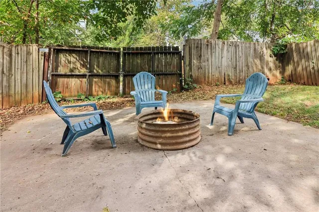 a view of a backyard with two chairs and a wooden fence