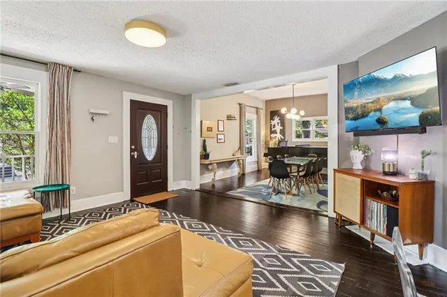 a living room with hard wood floors and a large window