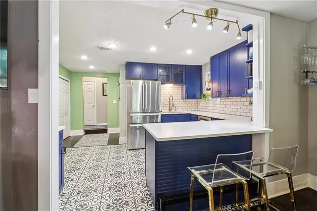 a kitchen with kitchen island a sink stainless steel appliances and cabinets
