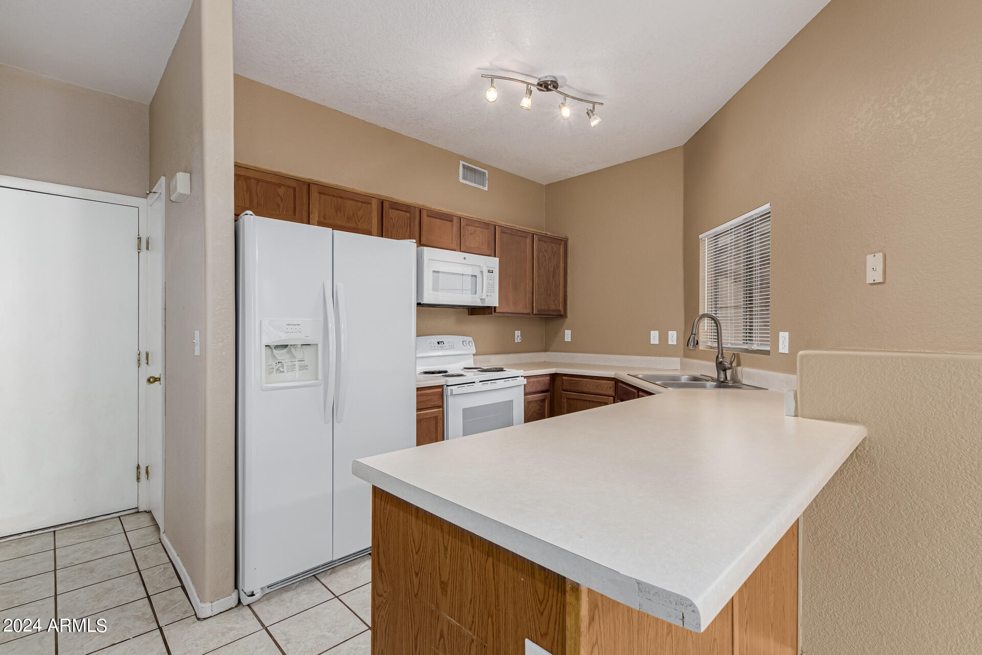 1371 South Boulder Street, Unit A Gilbert, AZ 85296 - Photo 15 of 43 a kitchen with a sink a stove a refrigerator and cabinets