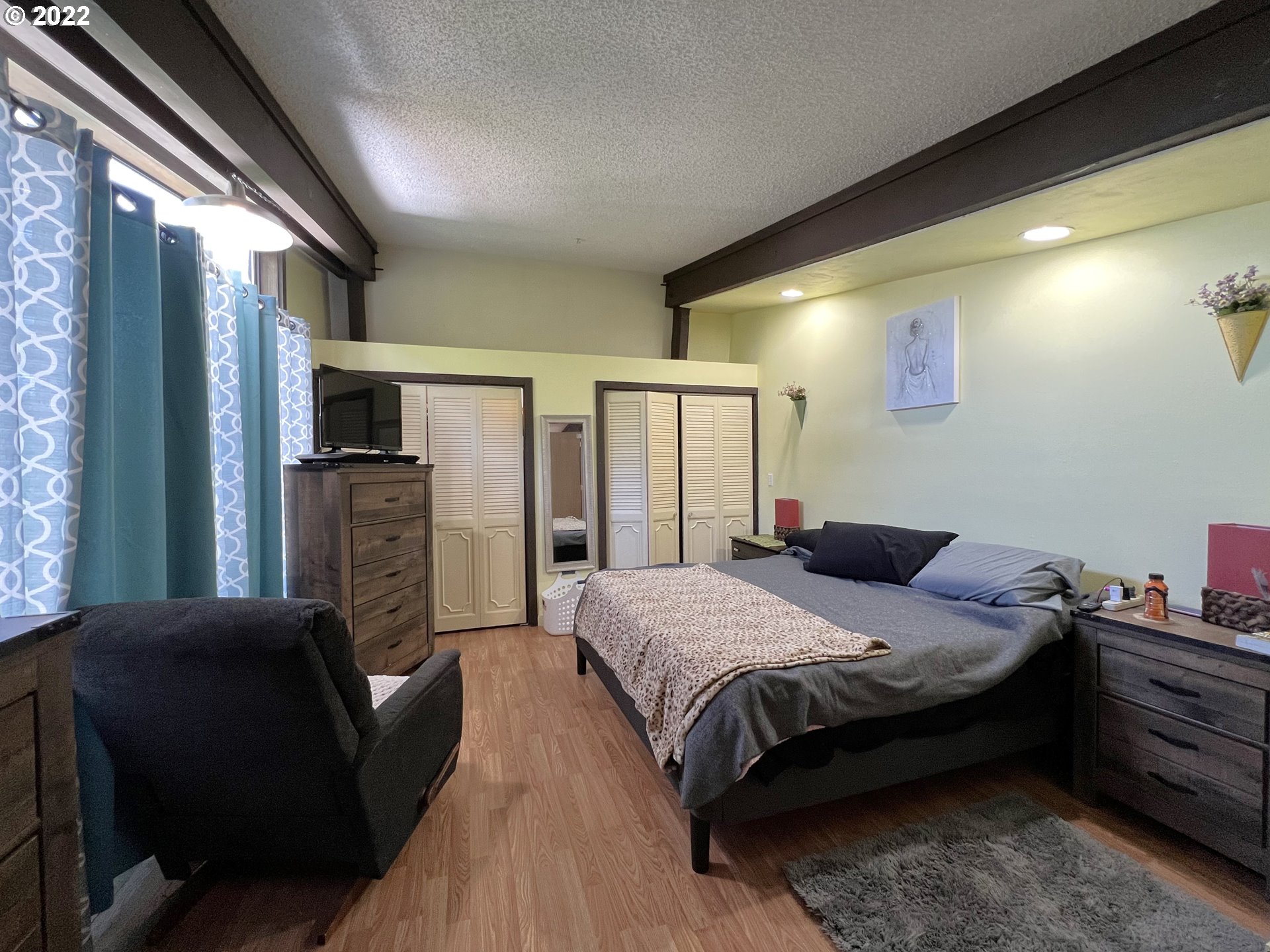2690 Everett Avenue North Bend, OR 97459 - Photo 15 of 32 a bedroom with a bed wooden floor and flat screen tv