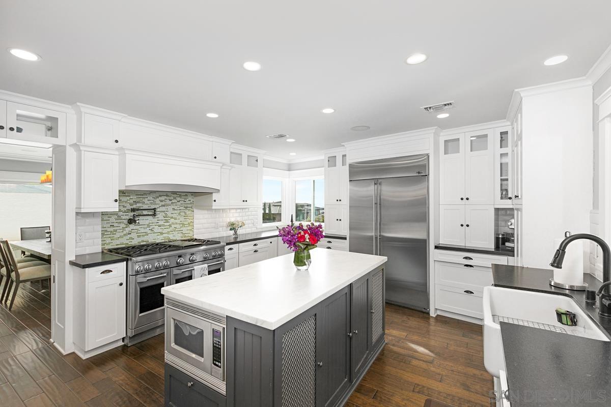 5524 Candlelight Drive La Jolla, CA 92037 - Photo 11 of 27 a kitchen that has a lot of cabinets in it and wooden floors