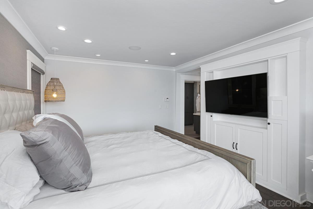 5524 Candlelight Drive La Jolla, CA 92037 - Photo 16 of 27 a bedroom with a large bed and a flat screen tv