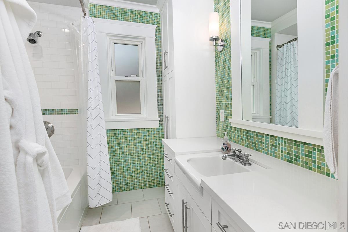 5524 Candlelight Drive La Jolla, CA 92037 - Photo 19 of 27 a bathroom with a sink and mirror with bathtub