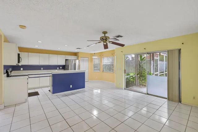 a large kitchen with stainless steel appliances a stove a sink a microwave and a refrigerator