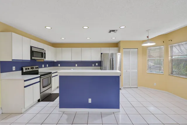 a kitchen with stainless steel appliances a refrigerator sink and microwave