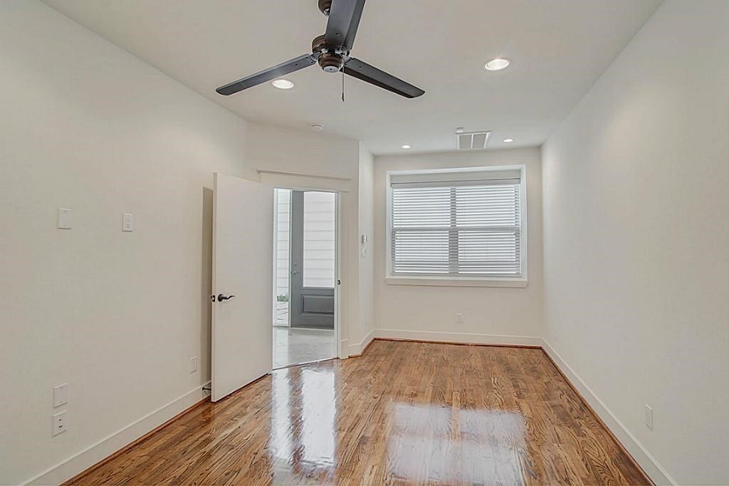 5810 Venice Street Houston, TX 77007 - Photo 11 of 31 an empty room with wooden floor a ceiling fan and windows