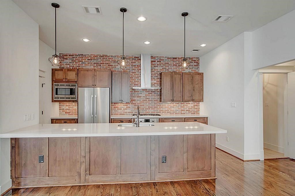 5810 Venice Street Houston, TX 77007 - Photo 6 of 31 a kitchen with kitchen island granite countertop a sink a counter top space stainless steel appliances and cabinets