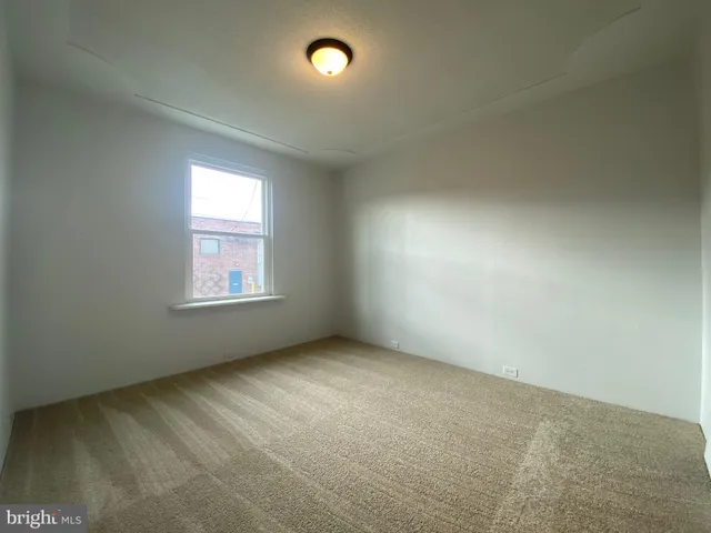 an empty room with closet area and windows