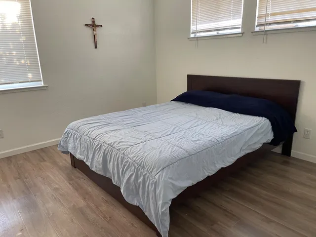 a bedroom with a bed and wooden floor