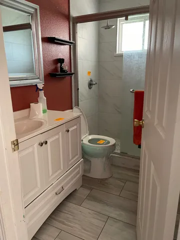 a bathroom with a sink toilet and mirror