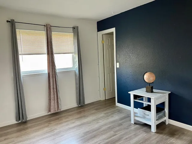 a view of a room with wooden floor and bathroom