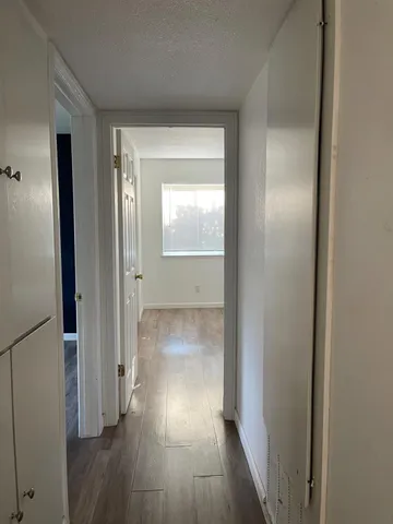 a view of a hallway with wooden floor