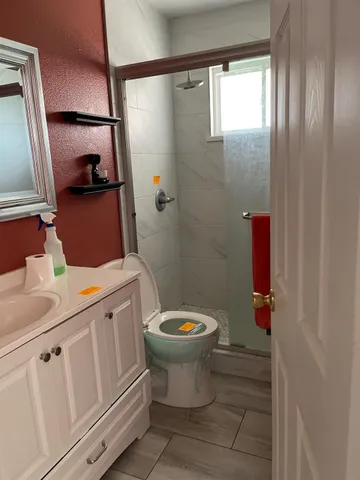 a bathroom with a sink a toilet and shower