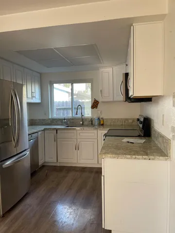 a kitchen with a sink a stove a refrigerator and cabinets