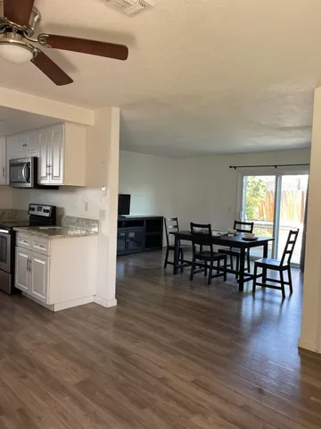 a kitchen with stainless steel appliances granite countertop wooden floors and white cabinets