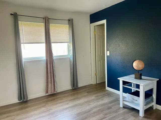 a view of a livingroom with wooden floor and window