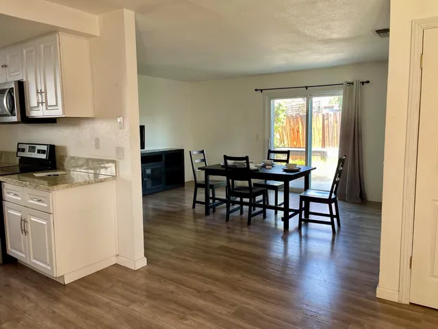 a view of dining table chairs and wooden floor
