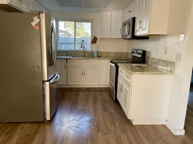 a kitchen with a sink a microwave and cabinets