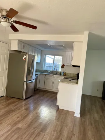 a kitchen with stainless steel appliances a refrigerator and wooden floor